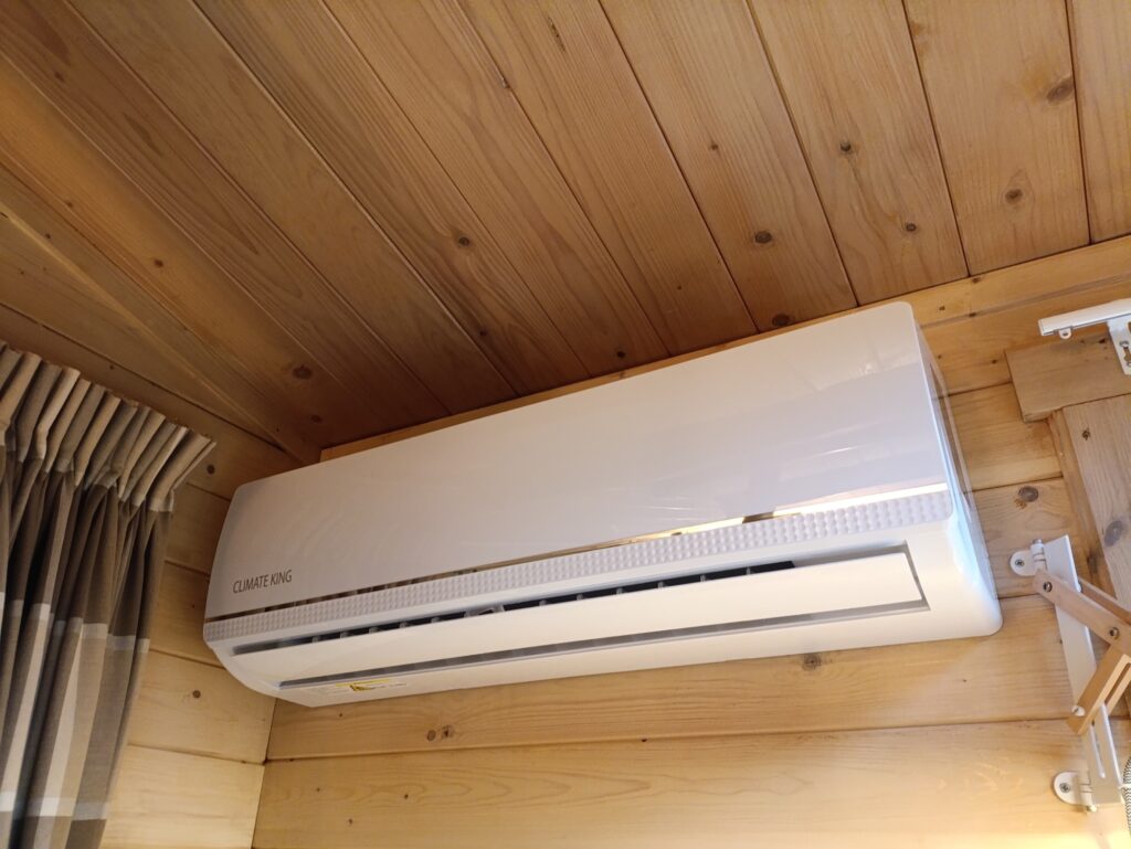 Climate King split airco binnenunit aan een houten wand